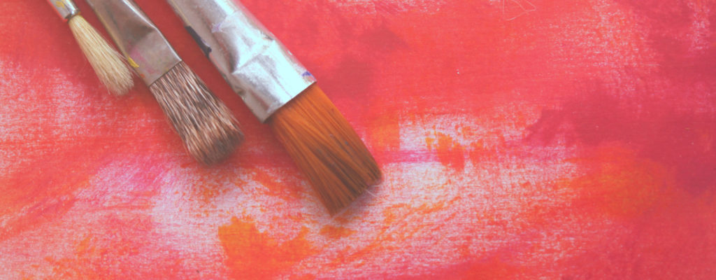 three-paint-brushes-on-red-pink-hues-canvas